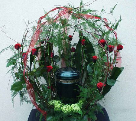 Urne umarmt mit roten Rosen - März